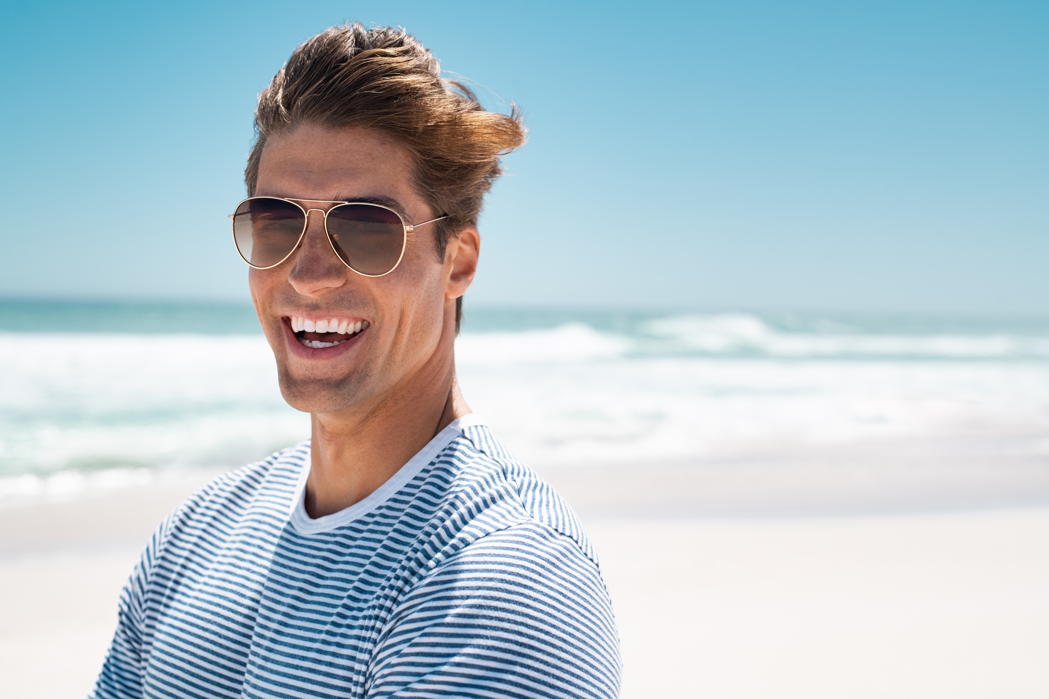 Portrait of joyful man enjoying summer holiday at beach
